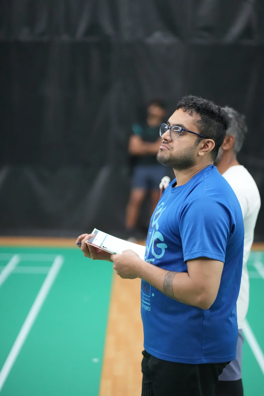 A courtside official following play with a scoresheet in hand